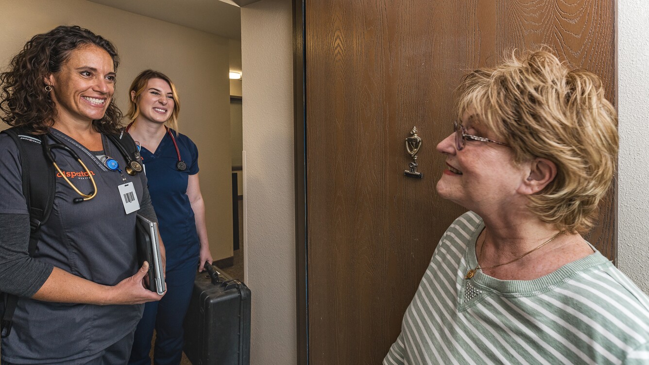 DispatchHealth medical team arriving at elderly patient's door with medical equipment for home healthcare visit