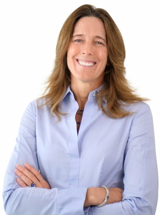 Jennifer Webster smiling professional portrait with arms crossed wearing light blue shirt